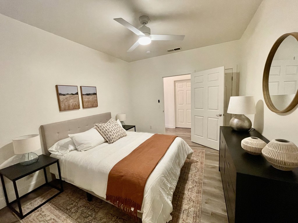 a bedroom with a bed and a ceiling fan  at Polo Villas, Bakersfield